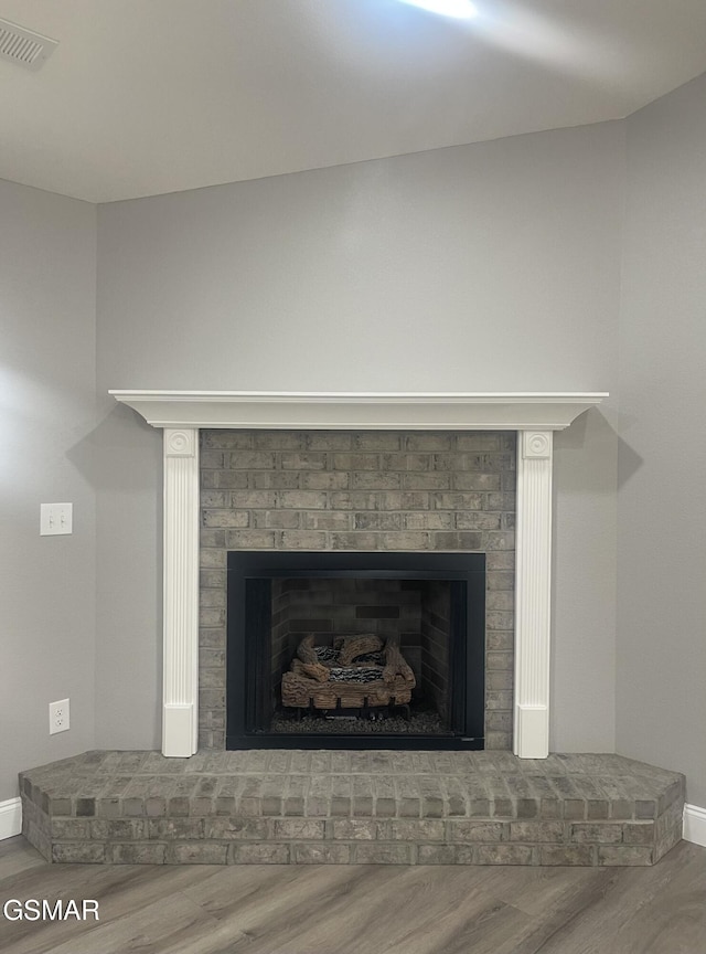 room details with a brick fireplace and hardwood / wood-style floors