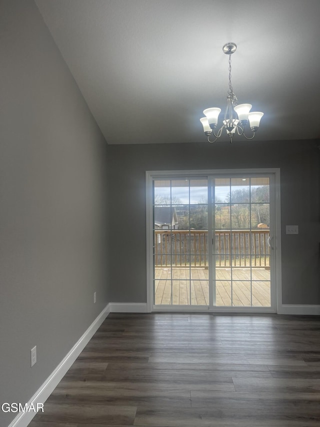 unfurnished dining area featuring dark wood-type flooring and a chandelier