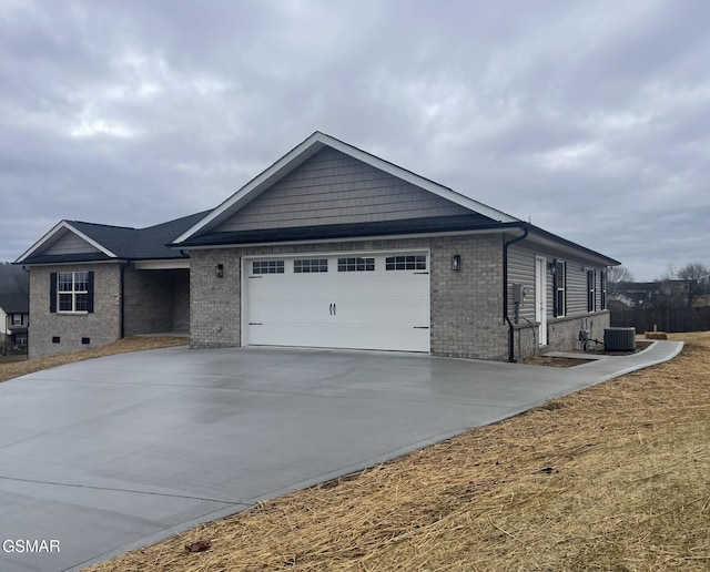 view of front of home featuring a garage and central air condition unit