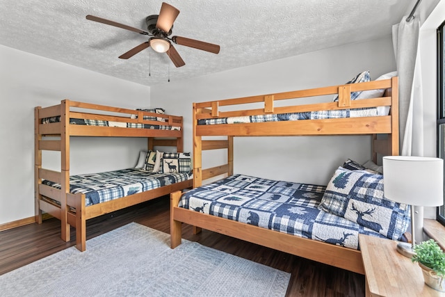 bedroom with ceiling fan, hardwood / wood-style floors, and a textured ceiling