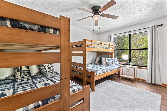 bedroom with ceiling fan, a textured ceiling, and hardwood / wood-style flooring