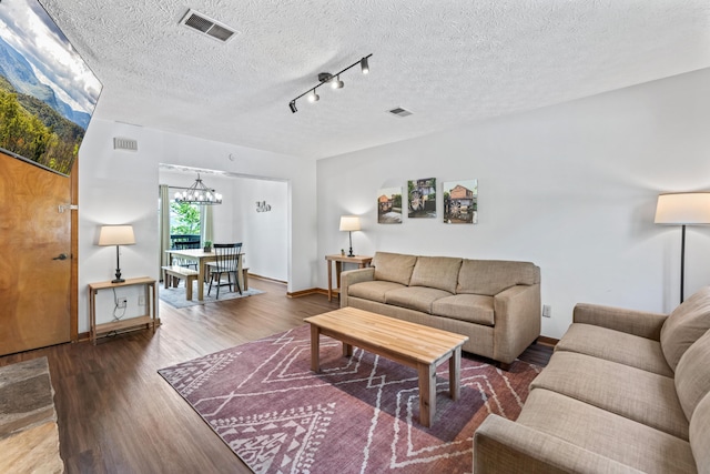 living room featuring hardwood / wood-style flooring, a chandelier, and a textured ceiling