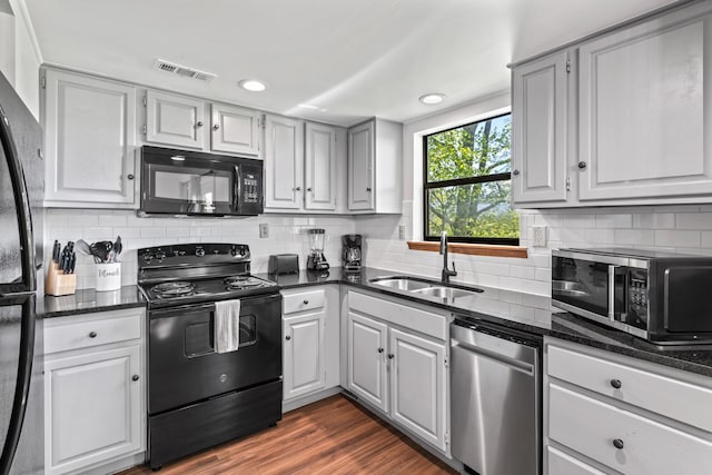 kitchen featuring sink, black appliances, decorative backsplash, and dark hardwood / wood-style floors