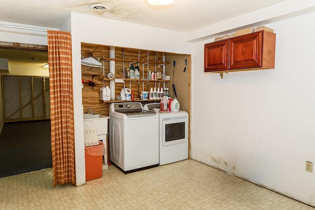 laundry area with a textured ceiling, washing machine and dryer, laundry area, visible vents, and light floors