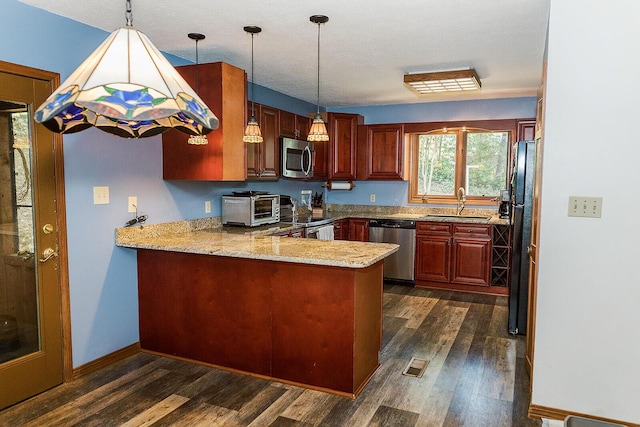 kitchen with stainless steel appliances, a peninsula, dark wood-style flooring, a sink, and visible vents