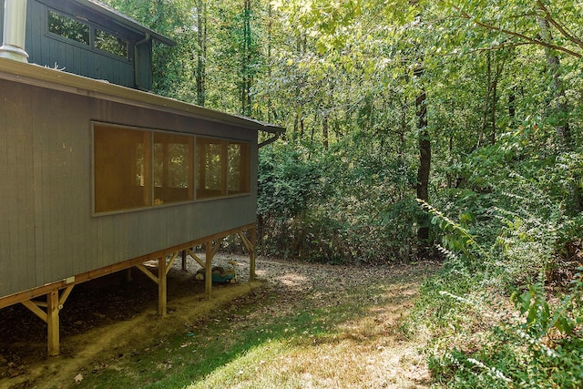 view of yard with a sunroom and a wooded view