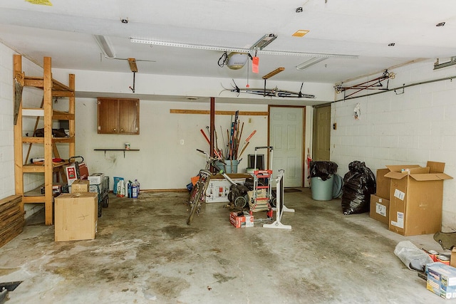 garage with concrete block wall and a garage door opener