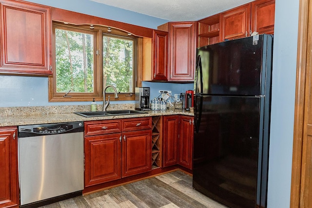 kitchen featuring dark wood-style flooring, a sink, stainless steel dishwasher, freestanding refrigerator, and open shelves