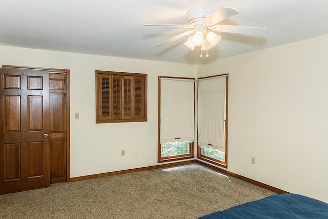 unfurnished bedroom with carpet, a ceiling fan, and baseboards