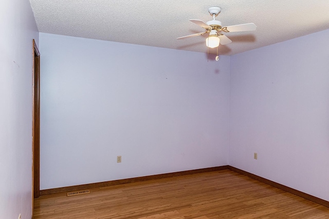 unfurnished room with baseboards, visible vents, ceiling fan, a textured ceiling, and light wood-style floors