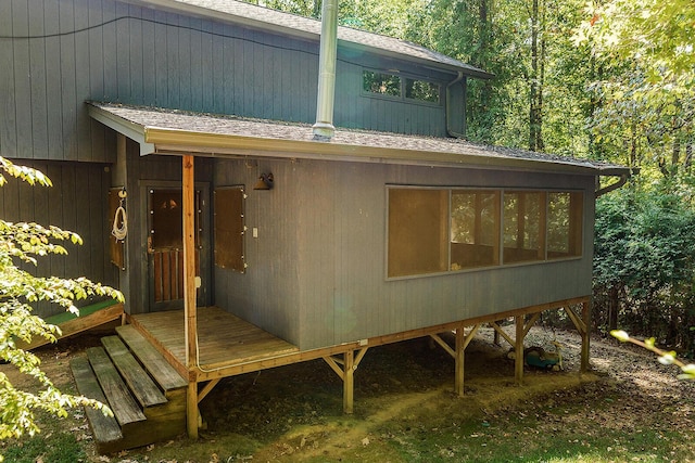 entrance to property featuring roof with shingles