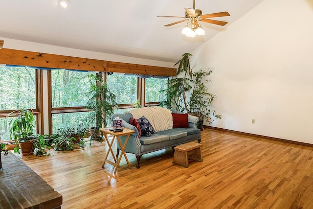 living area featuring high vaulted ceiling, light wood-style flooring, baseboards, and ceiling fan