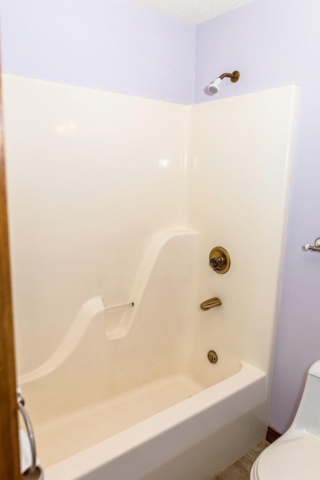 bathroom featuring a textured ceiling and toilet