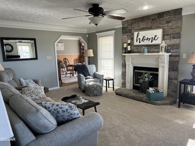 living room with ceiling fan, carpet floors, ornamental molding, and a textured ceiling