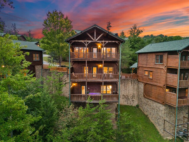 back house at dusk featuring a balcony