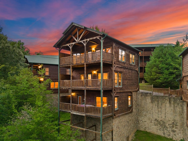 back house at dusk featuring a balcony