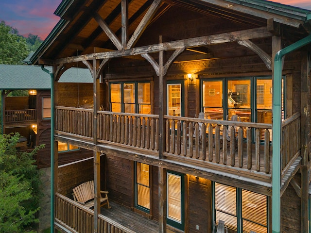 back house at dusk featuring a balcony