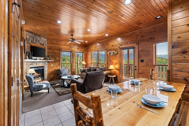 dining space with ceiling fan, light tile patterned flooring, a healthy amount of sunlight, and a fireplace