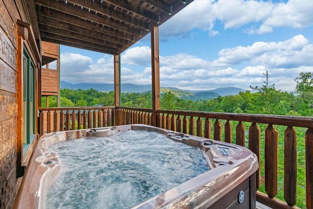 wooden deck with a mountain view and a hot tub