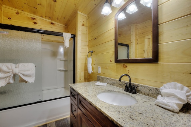 bathroom with wooden ceiling, enclosed tub / shower combo, wood-type flooring, wooden walls, and vanity