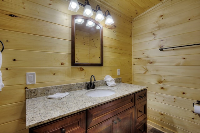 bathroom with vanity, wooden ceiling, and wood walls