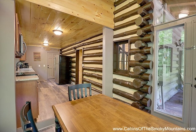 wine room with sink, log walls, wooden ceiling, and light wood-type flooring