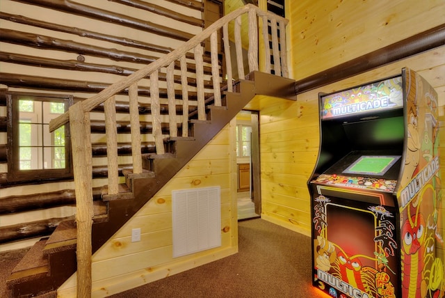 staircase featuring carpet flooring, wood walls, and beam ceiling