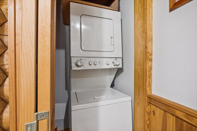 clothes washing area featuring stacked washer / dryer