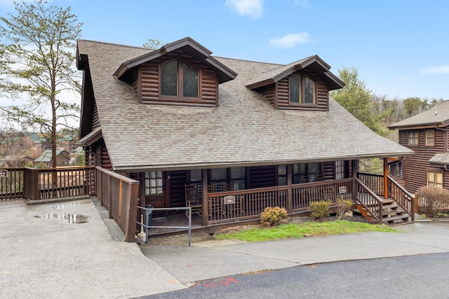 log cabin featuring covered porch