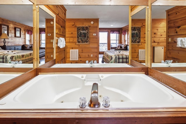 bathroom with tiled bath and wood walls