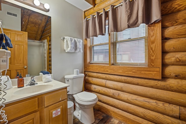 bathroom featuring hardwood / wood-style flooring, vanity, log walls, and toilet