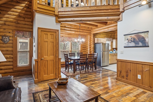 living room featuring an inviting chandelier, a towering ceiling, and light hardwood / wood-style floors