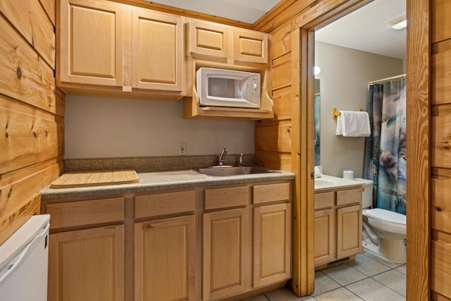 kitchen featuring light brown cabinetry, sink, and light tile patterned flooring