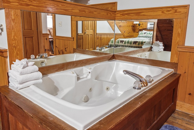 bathroom featuring wooden walls and a washtub