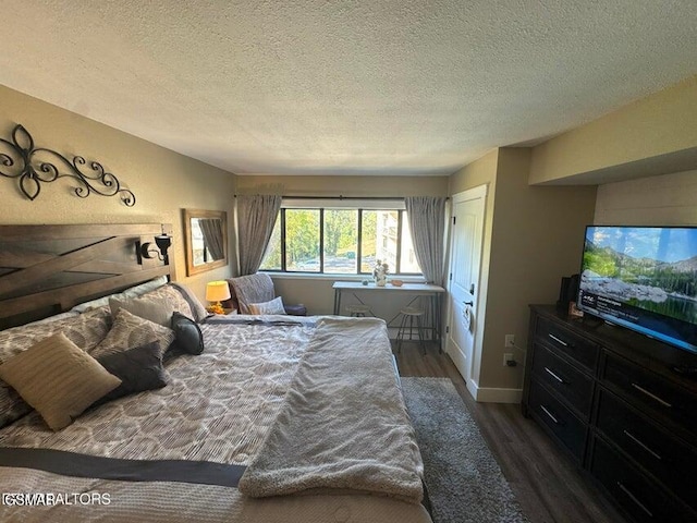 bedroom featuring a textured ceiling and dark hardwood / wood-style flooring