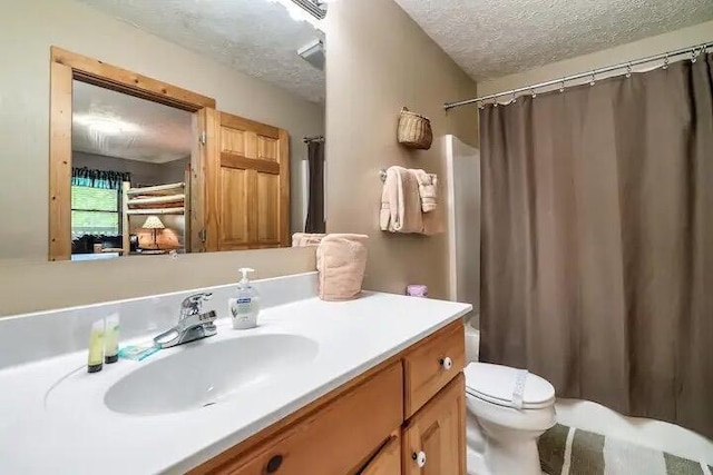 bathroom with vanity, a textured ceiling, and toilet