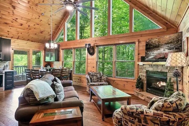 living room featuring a fireplace, wood-type flooring, high vaulted ceiling, and wooden walls