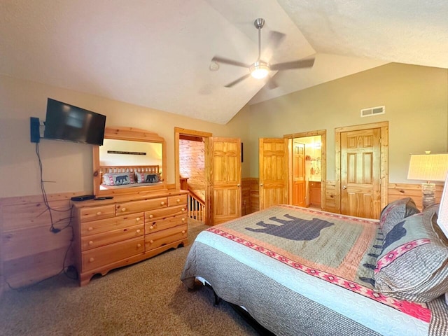 carpeted bedroom with ceiling fan, a closet, wooden walls, and vaulted ceiling