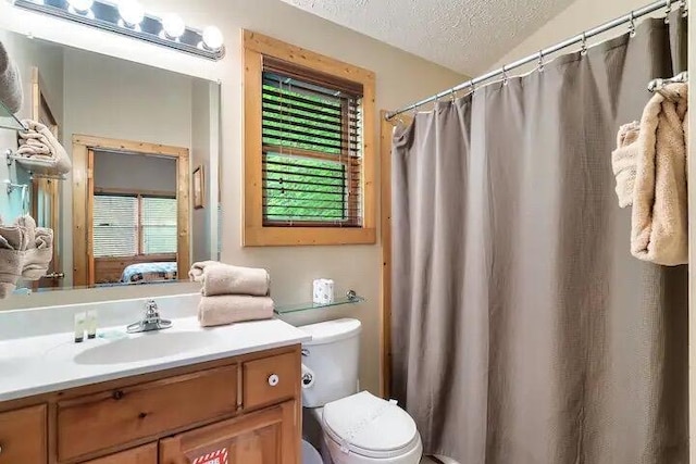 bathroom with vanity, toilet, and a textured ceiling