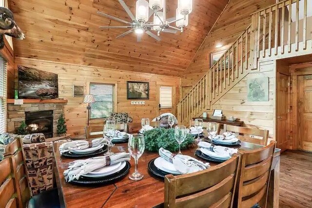 dining space with a chandelier, wood walls, a fireplace, and wood ceiling