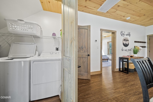 washroom with baseboards, wood ceiling, wood finished floors, and washer and clothes dryer