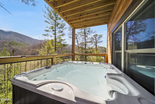 wooden deck featuring a mountain view, area for grilling, and a hot tub