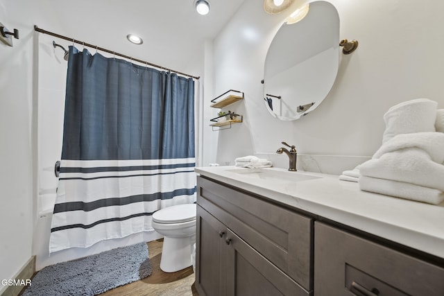 full bathroom featuring toilet, wood finished floors, and vanity