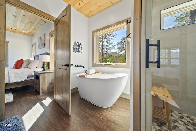 ensuite bathroom with lofted ceiling, a healthy amount of sunlight, wood finished floors, and connected bathroom