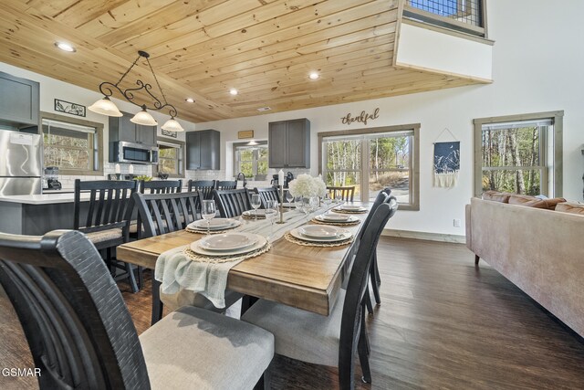 dining room with dark wood-style floors, recessed lighting, baseboards, wood ceiling, and a towering ceiling