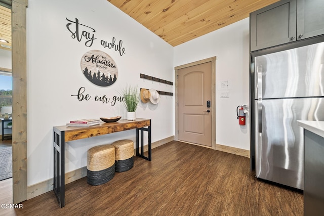 kitchen featuring dark wood-type flooring, freestanding refrigerator, light countertops, baseboards, and wood ceiling