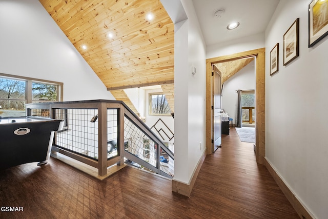 corridor with baseboards, high vaulted ceiling, wood ceiling, and wood finished floors