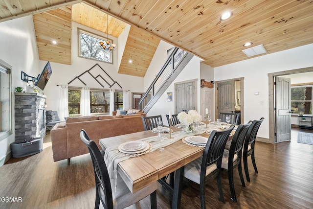 dining space with dark wood-style floors, stairway, a healthy amount of sunlight, and high vaulted ceiling