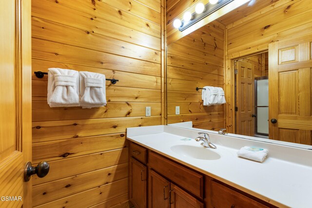 bathroom featuring vanity and wood walls