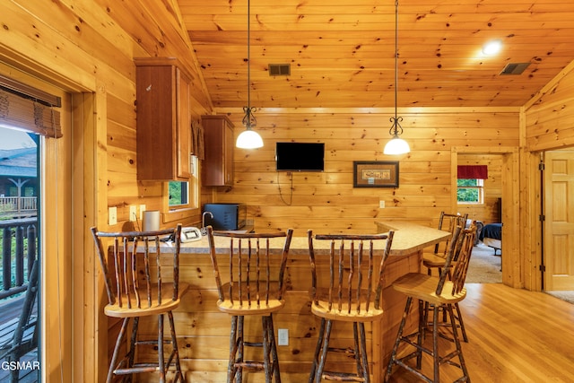 bar with pendant lighting, light hardwood / wood-style floors, vaulted ceiling, and wooden ceiling